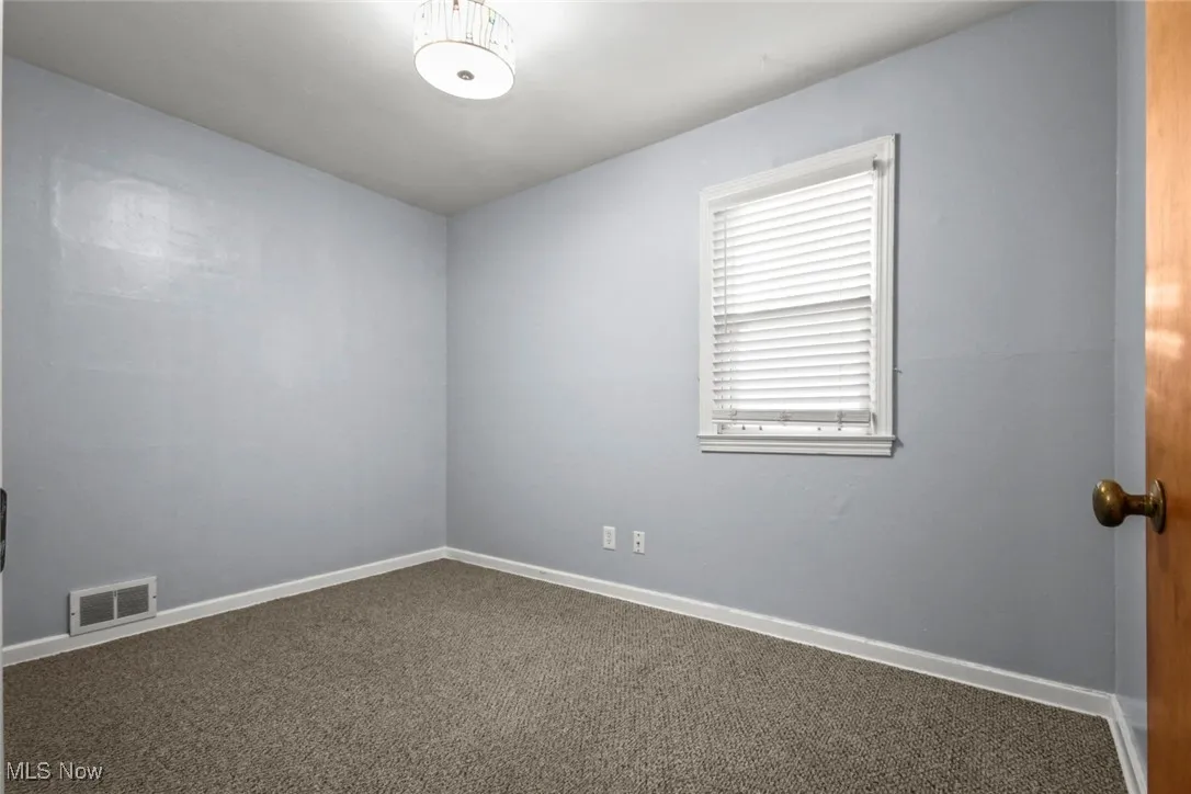 Empty room featuring carpet floors and baseboards