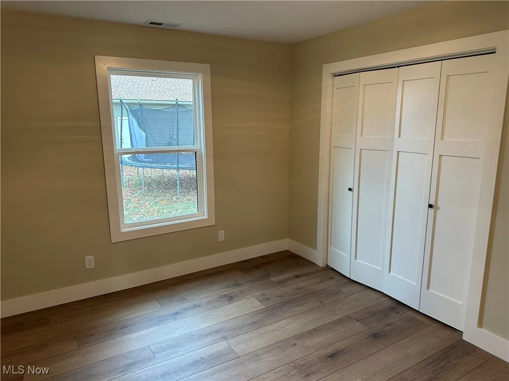 Unfurnished bedroom with a closet and LVT wood look floors
