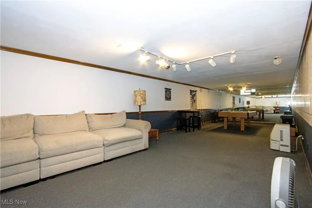 Carpeted living area featuring billiards and ornamental molding