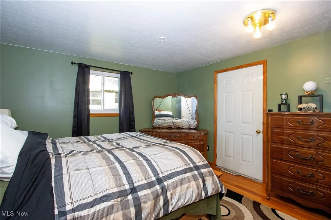 Bedroom featuring wood finished floors and a textured ceiling