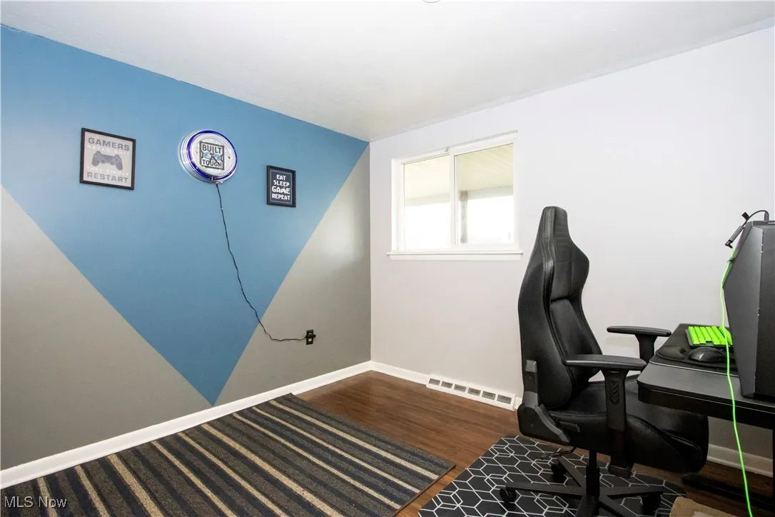 Office area with dark wood-style floors and baseboards