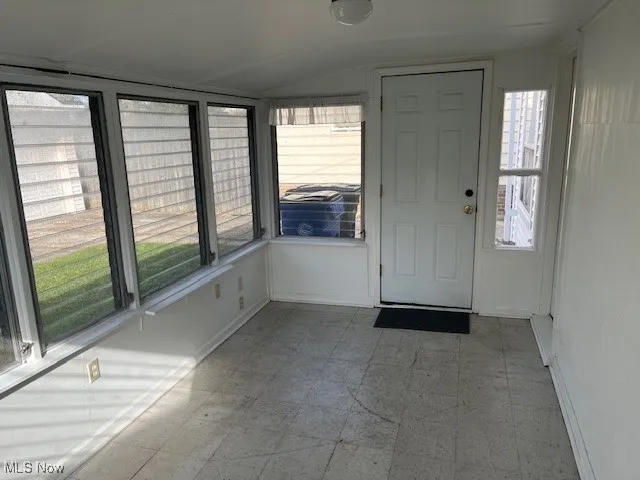 Unfurnished sunroom with vaulted ceiling