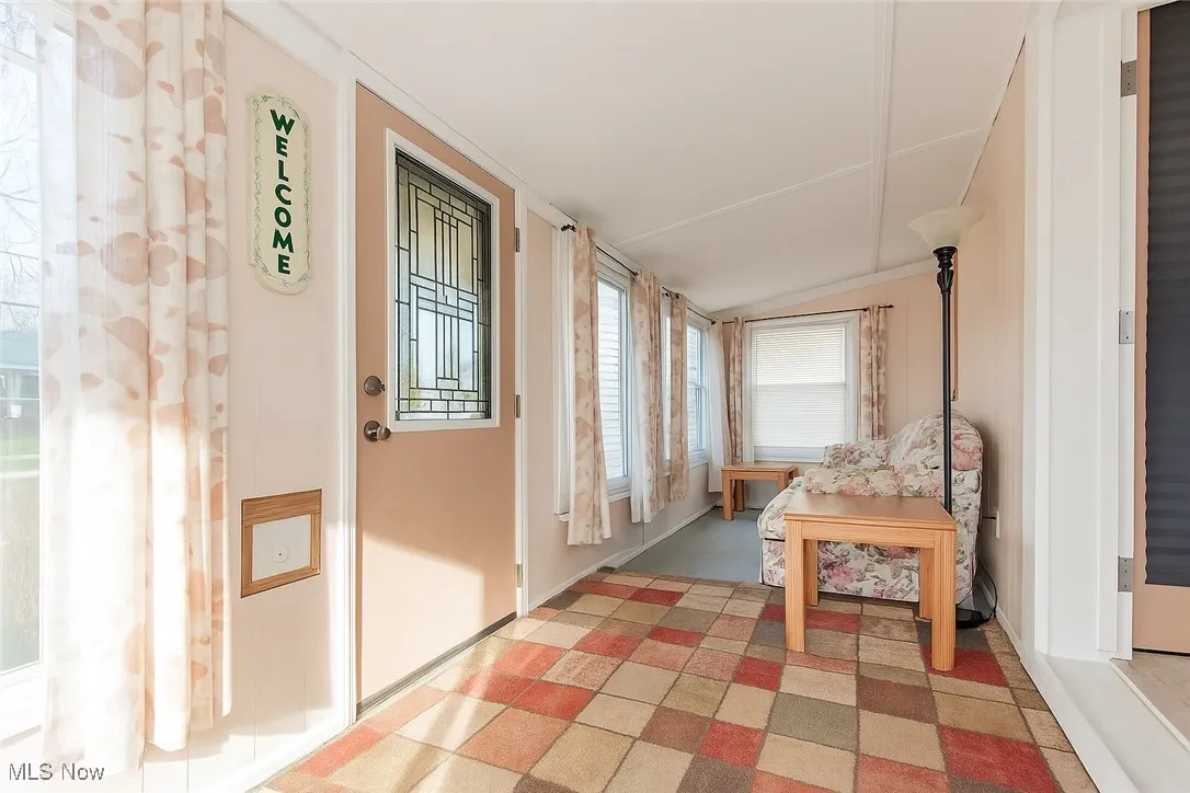 Sunroom / solarium with lofted ceiling and baseboards