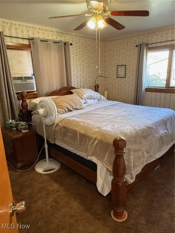 Carpeted bedroom with ceiling fan and cooling unit