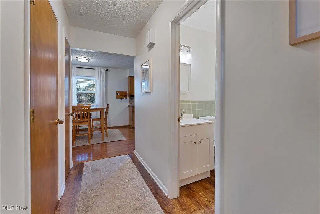 Hall featuring wood finished floors and a textured ceiling