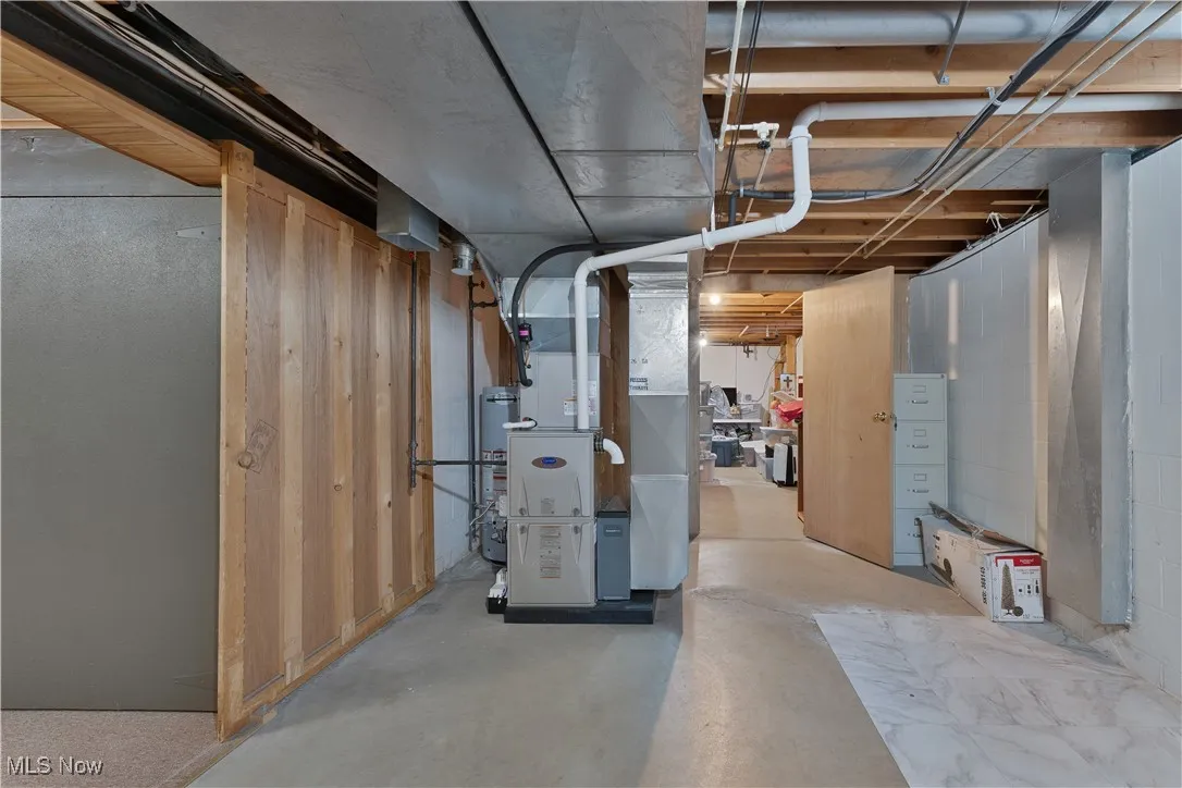 Unfinished below grade area with heating unit and gas water heater