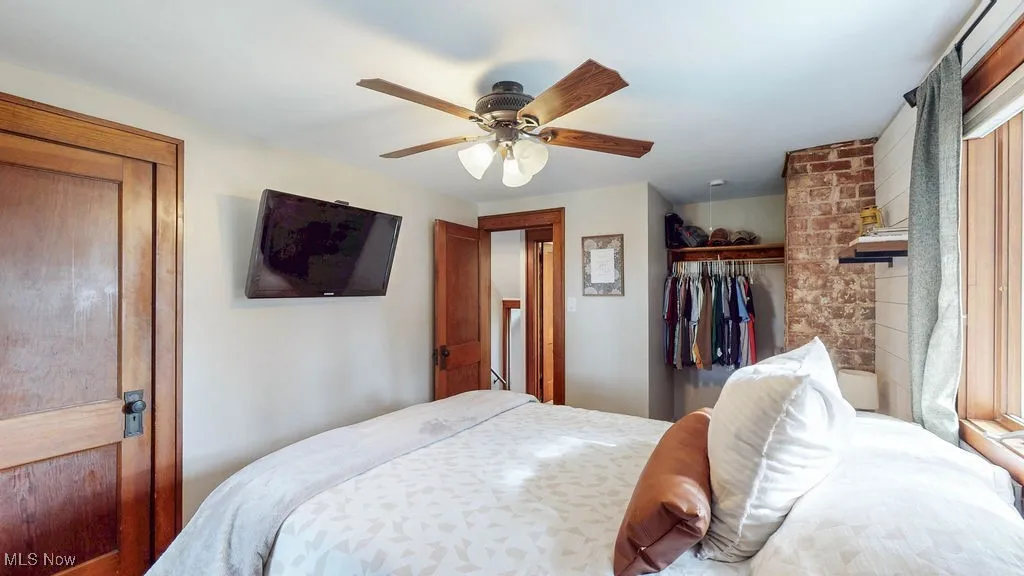 Another view of the primary bedroom featuring carpeting, natural woodwork, and ample closet space.