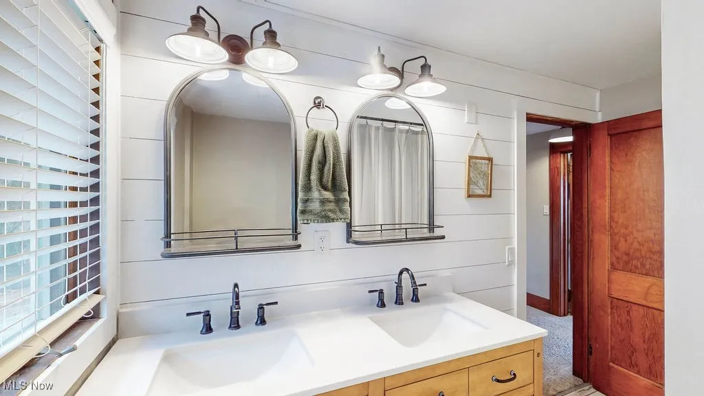 Dual vanity sinks, with mirrors and lighting.