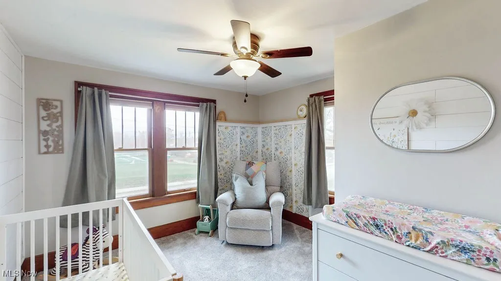 Warm and cozy bedroom with lots of natural light, carpeting and ceiling fan.