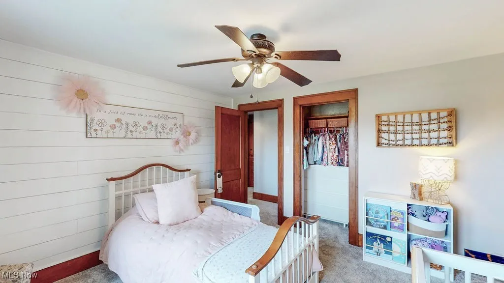 Spacious bedroom with carpeting, ample closet space and ceiling fan.