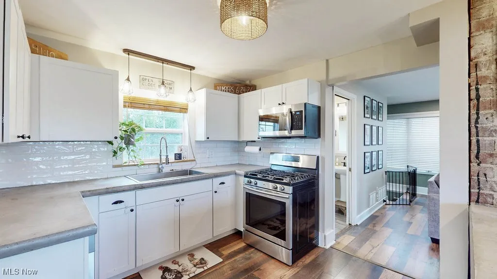Updated kitchen with concrete countertops, white cabinetry, LVP flooring.