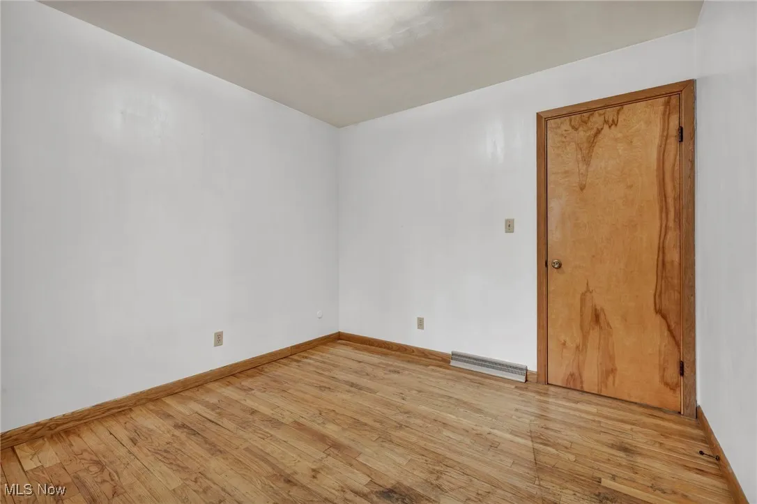 Unfurnished room with light wood-type flooring and baseboards