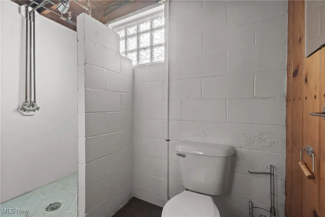 Full bath featuring a stall shower and toilet