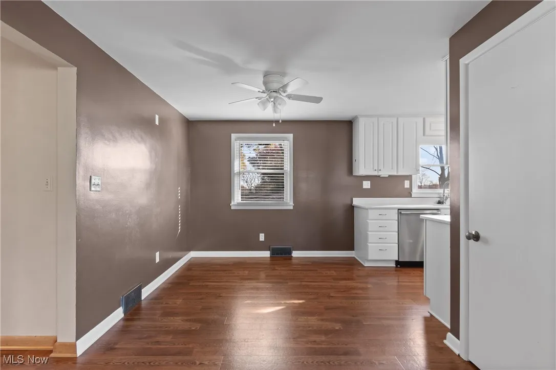 Unfurnished dining area featuring dark wood finished floors and ceiling fan