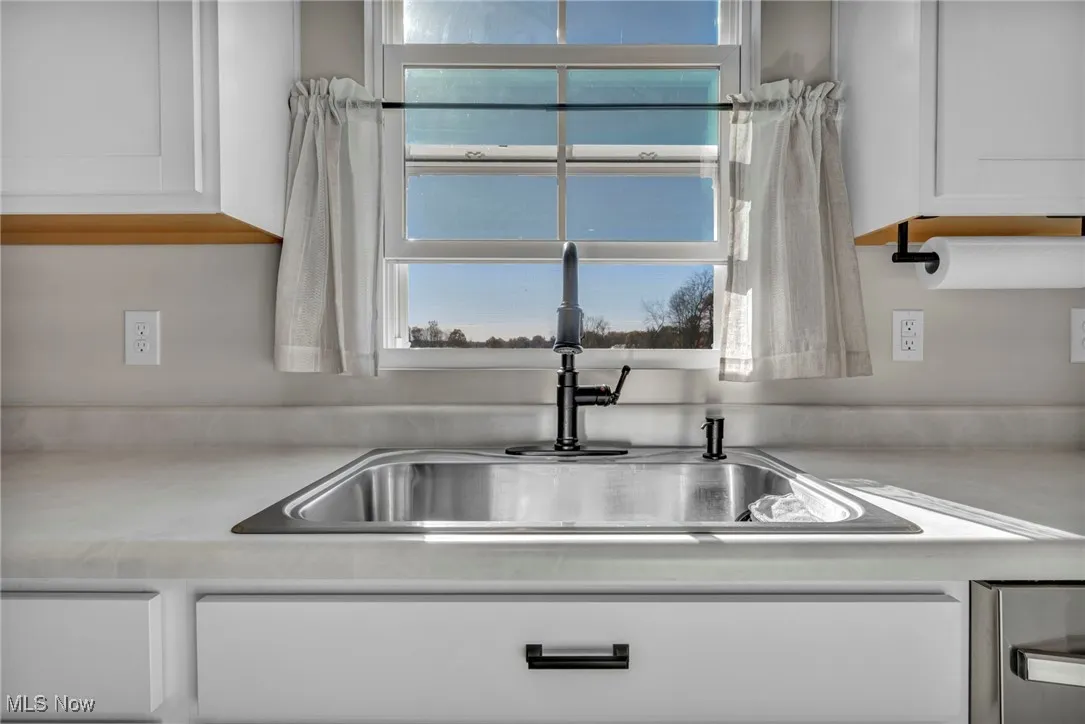 Kitchen view of white cabinets and light countertops