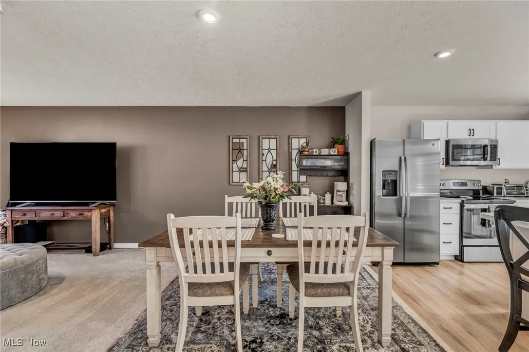 Dining space featuring a textured ceiling, recessed lighting, and light wood-style flooring