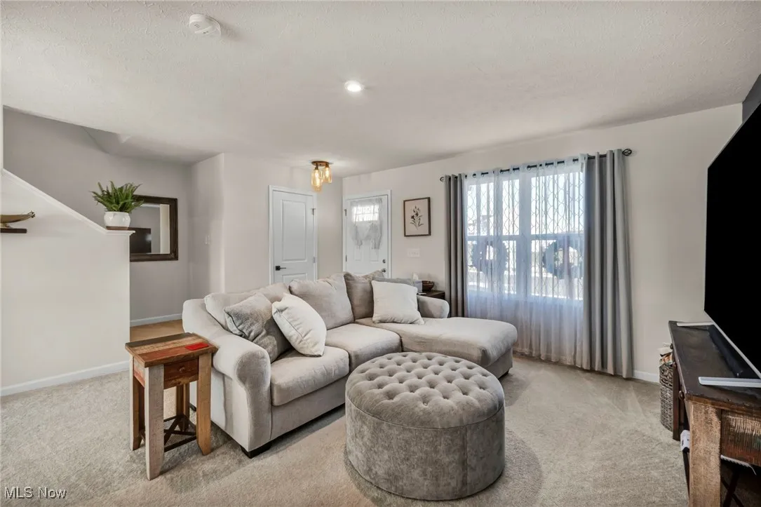 Carpeted living room with baseboards and a textured ceiling