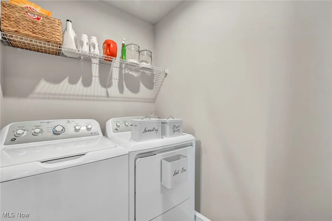 Washroom with washer and dryer and baseboards
