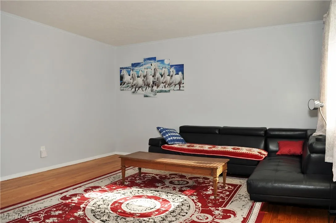 Living area featuring wood finished floors and crown molding