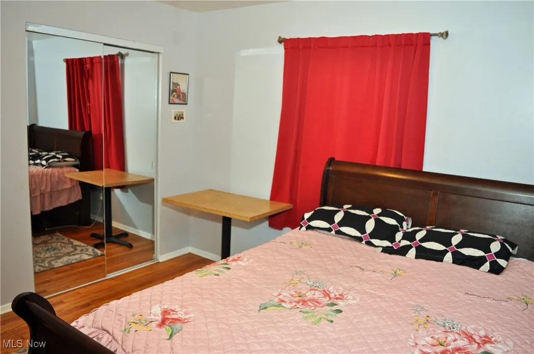 Bedroom with wood finished floors and a closet