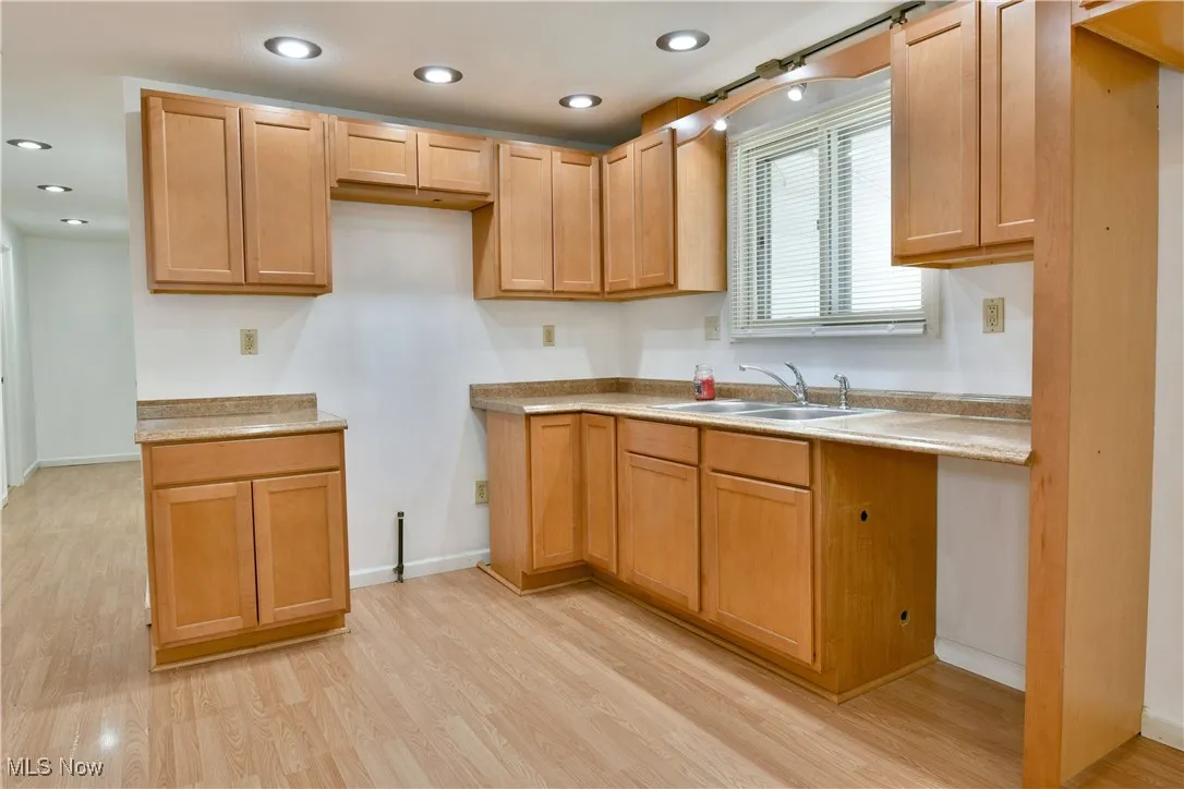 Kitchen with light wood-style flooring, light countertops, and recessed lighting
