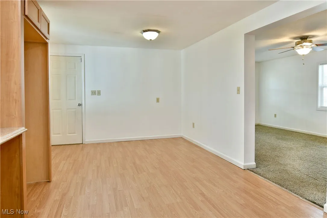 Empty room with a ceiling fan and light wood-style floors