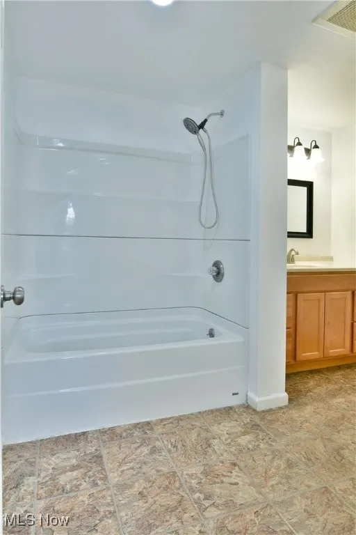 Full bath with vanity and shower / washtub combination