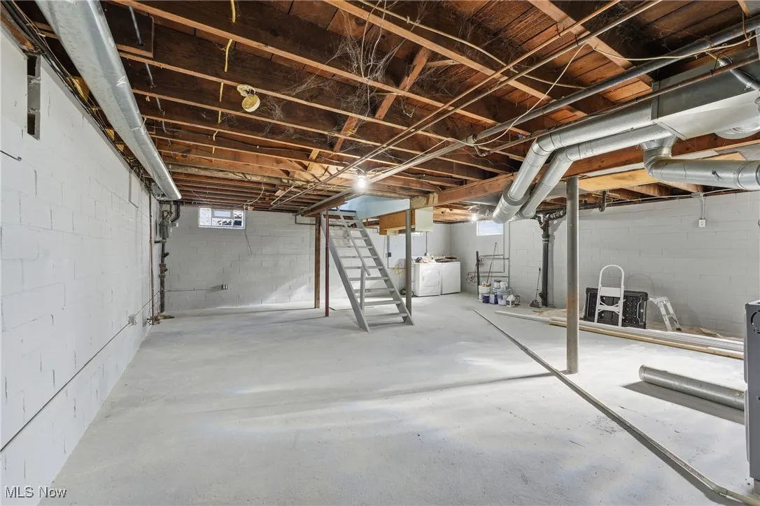 Basement featuring stairway, plenty of natural light, and washing machine and clothes dryer
