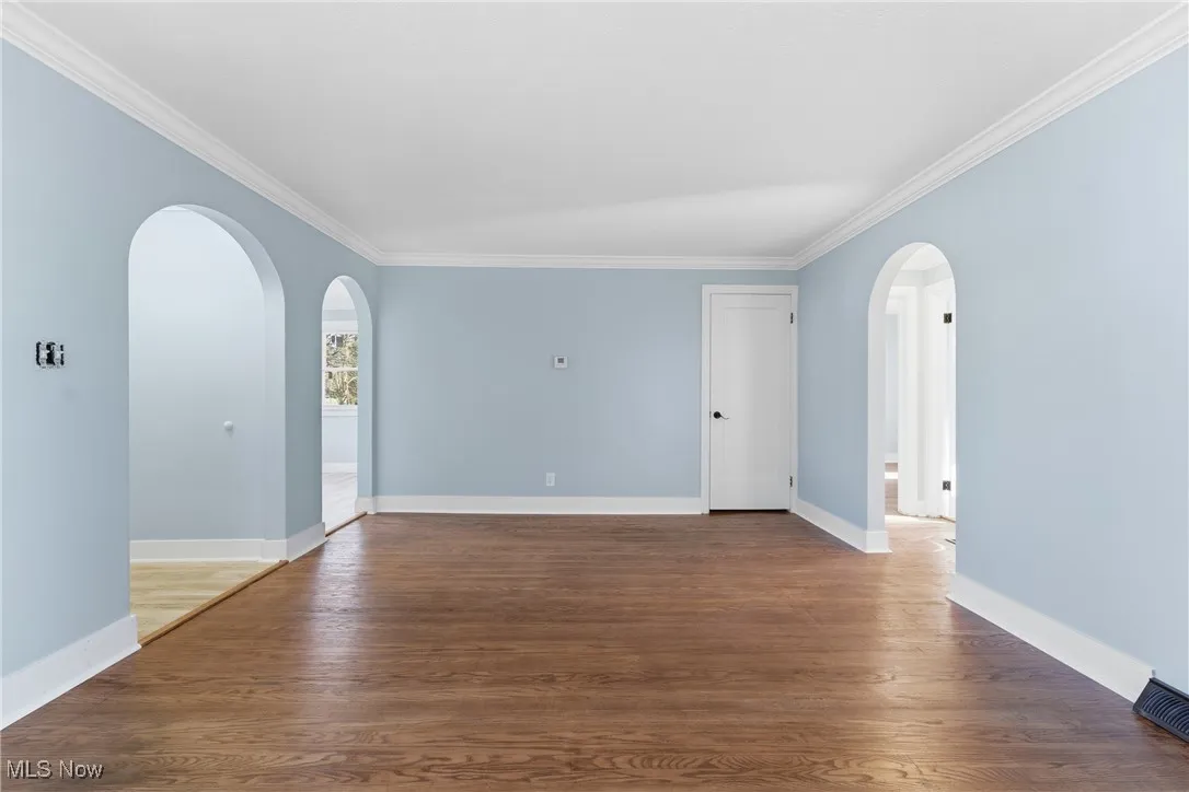 Featuring arched walkways, ornamental molding, and wood finished floors