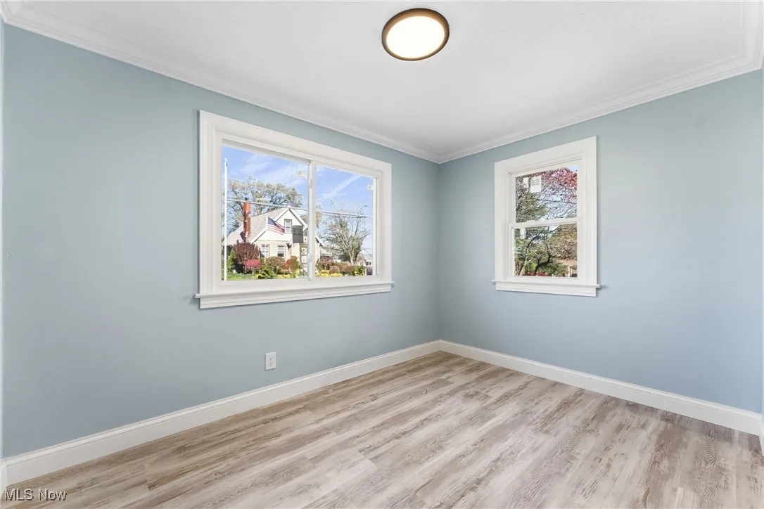Featuring crown molding and light wood finished floors