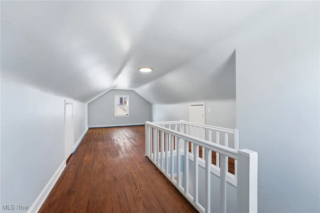 dark wood-type flooring and lofted ceiling