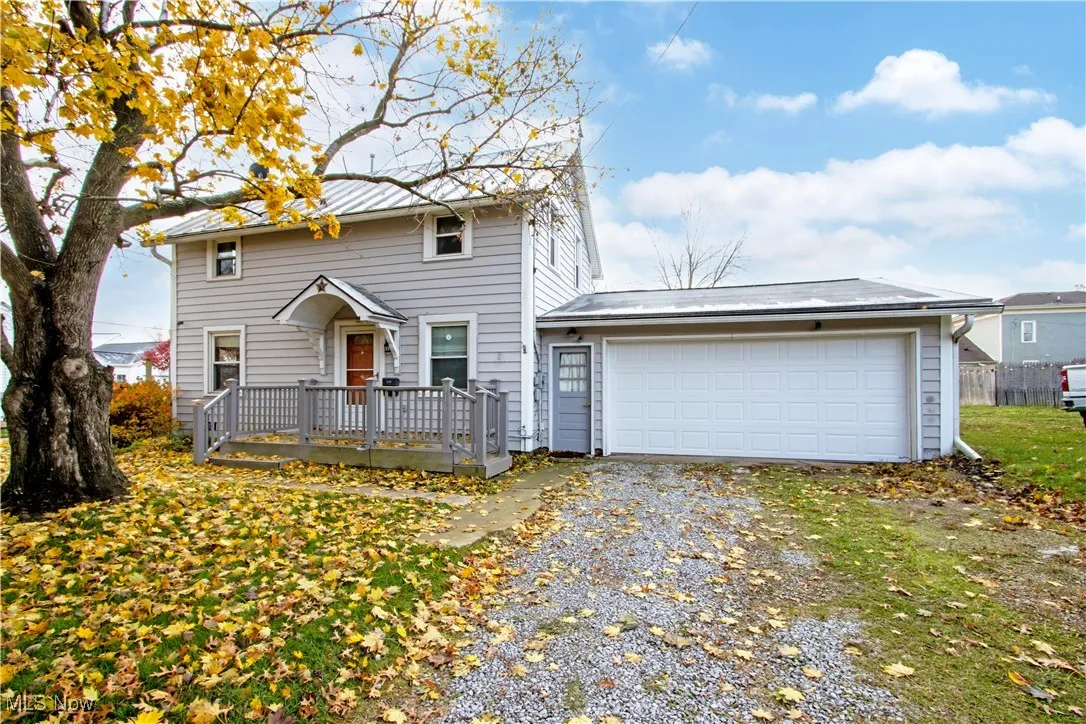 View of front of property featuring driveway, a garage, and a deck