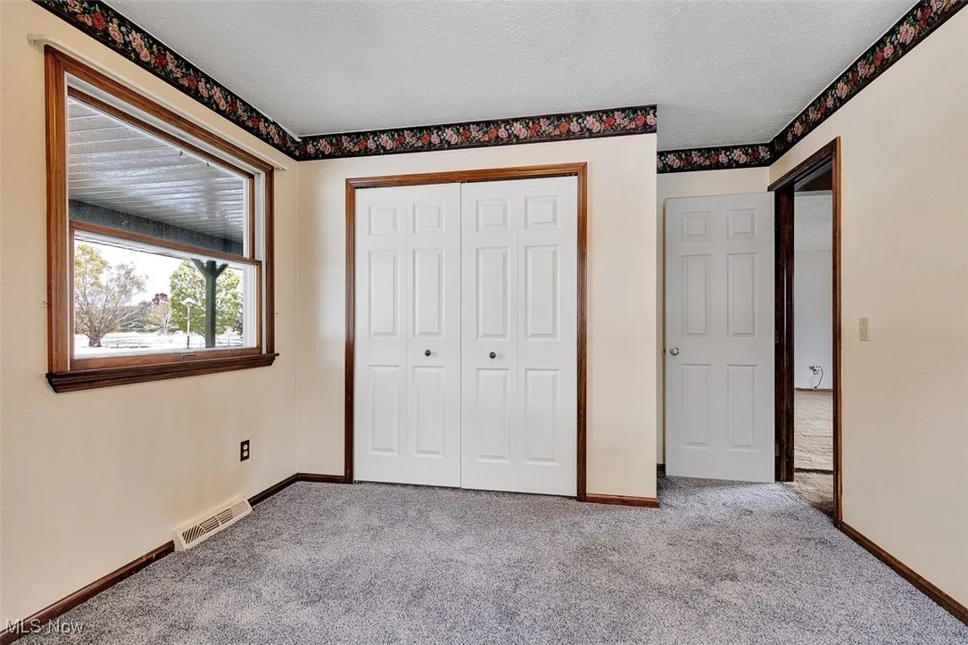 Unfurnished bedroom with carpet, a closet, and a textured ceiling