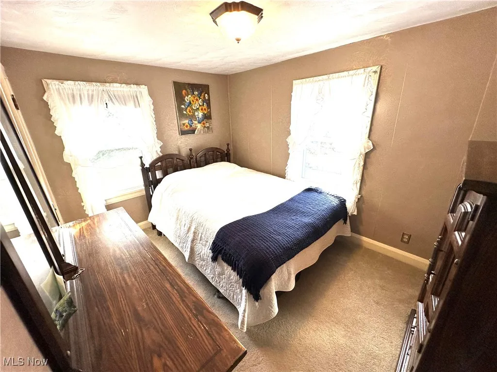 Bedroom with carpet floors, a textured wall, and a textured ceiling