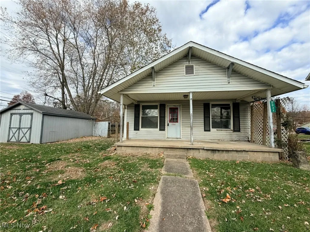 Bungalow-style house with covered porch, a front yard, and a shed