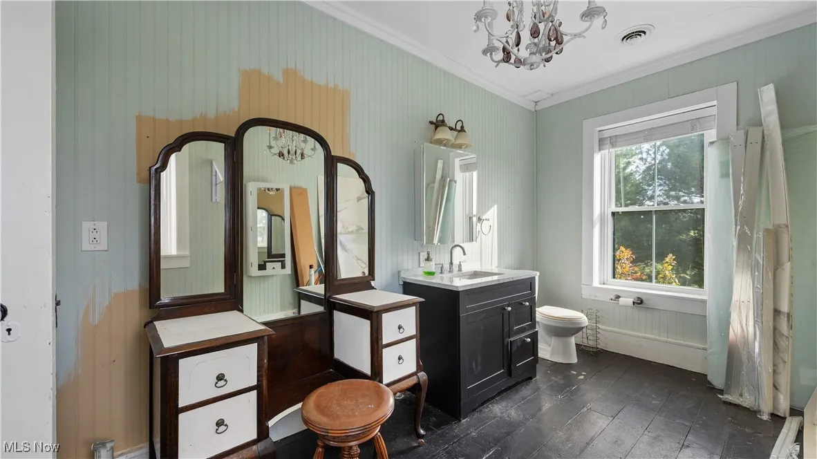 Full bathroom featuring a chandelier, vanity, ornamental molding, dark wood finished floors, and a shower with shower curtain