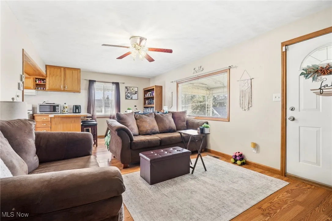Living room with light wood finished floors and a ceiling fan