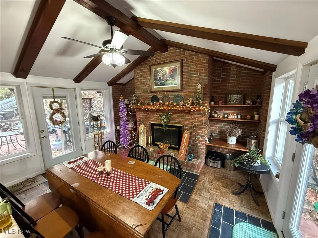 Dining room featuring a brick fireplace and a ceiling fan