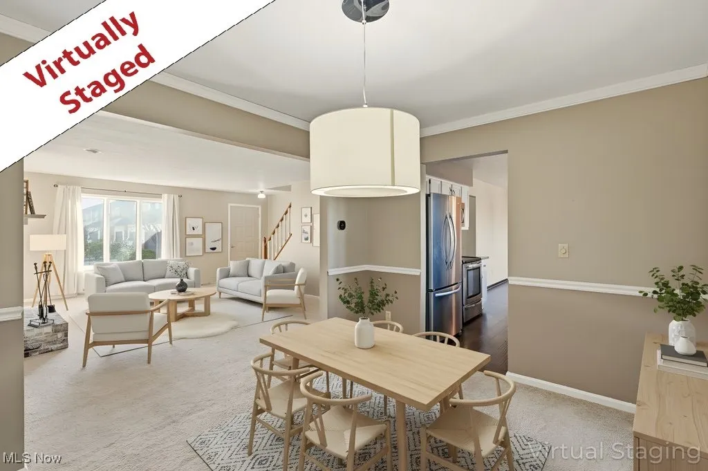 Carpeted dining area featuring ornamental molding and stairway