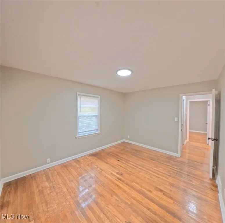 Empty room with light wood-style flooring and baseboards