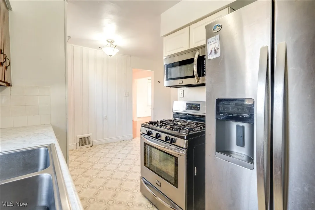 Kitchen featuring stainless steel appliances, light countertops, and light flooring