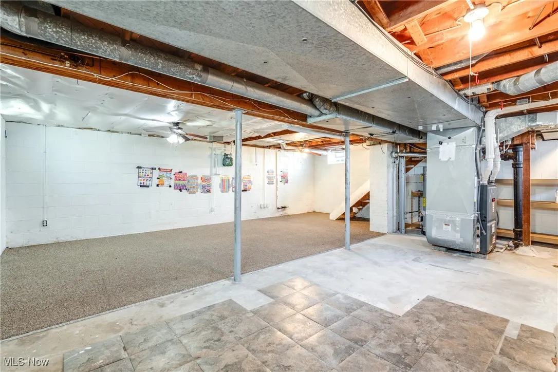 Below grade area with heating unit and stairs