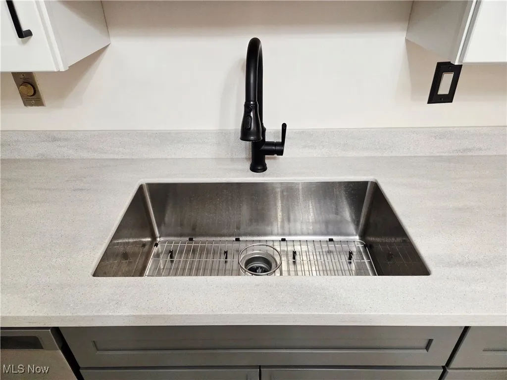Kitchen view of light stone countertops and gray cabinets