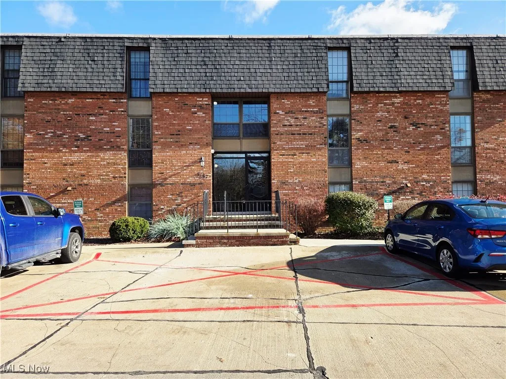 View of property featuring uncovered parking