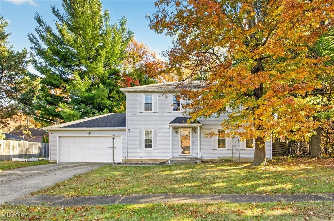 Colonial home featuring a garage and concrete driveway