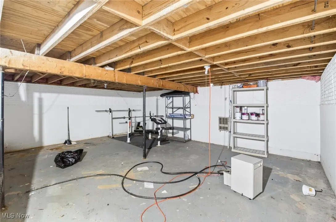 Unfinished below grade area featuring heating unit