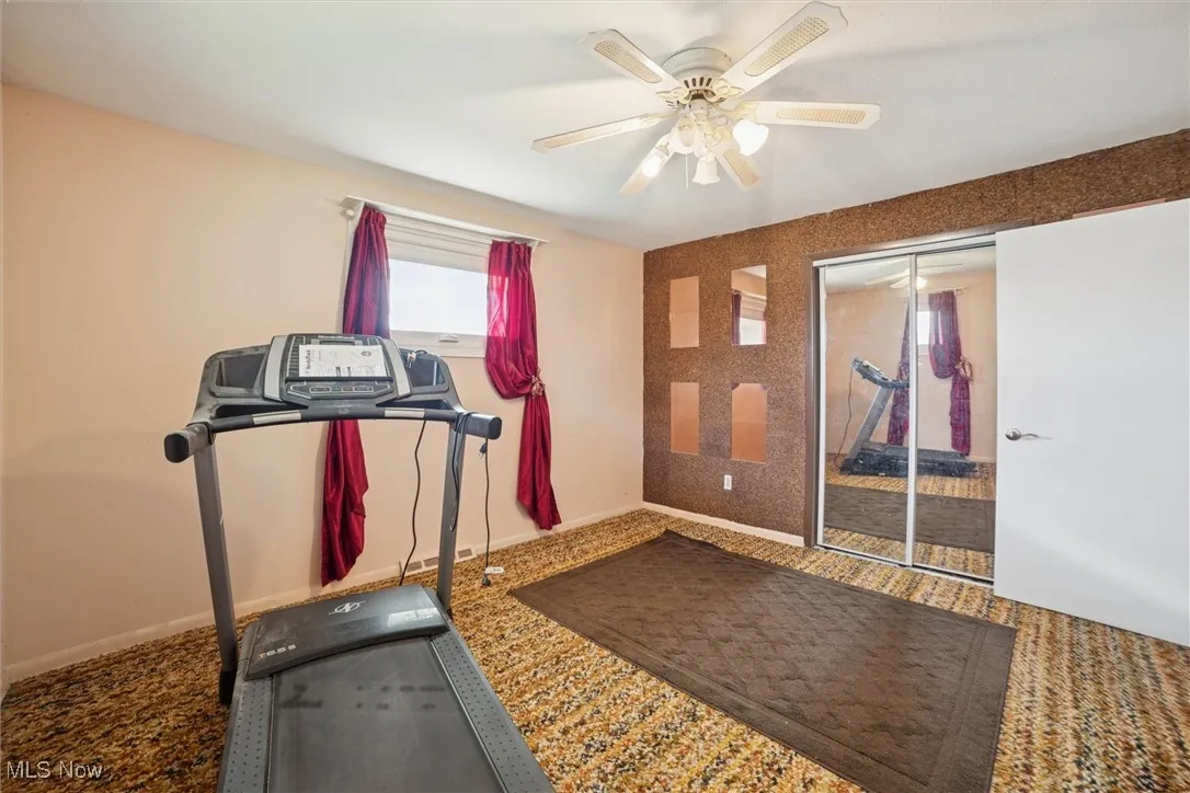 Workout room with baseboards and ceiling fan