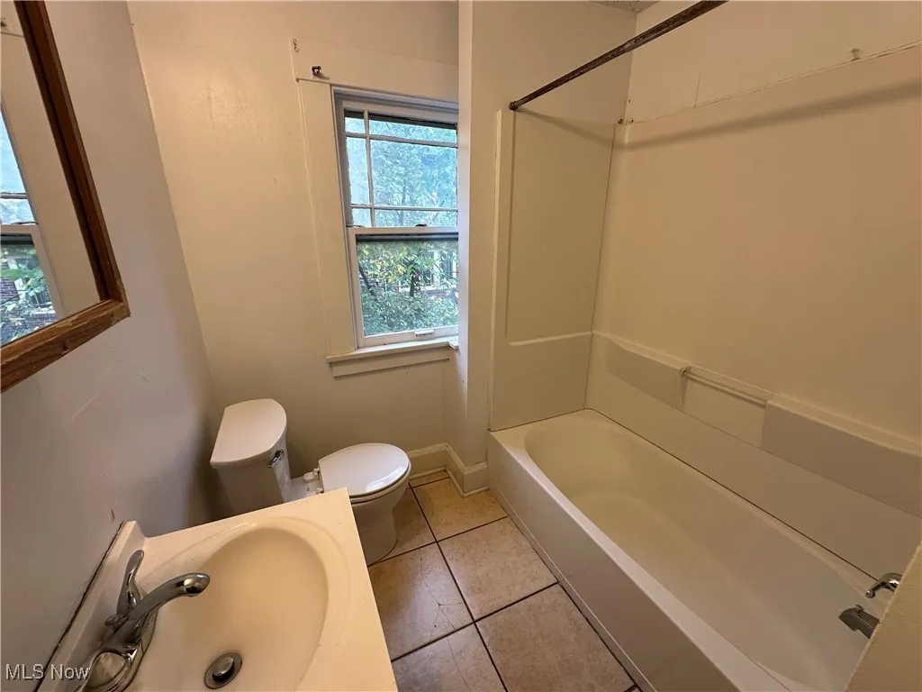 Bathroom featuring light tile patterned floors, shower / washtub combination, and vanity