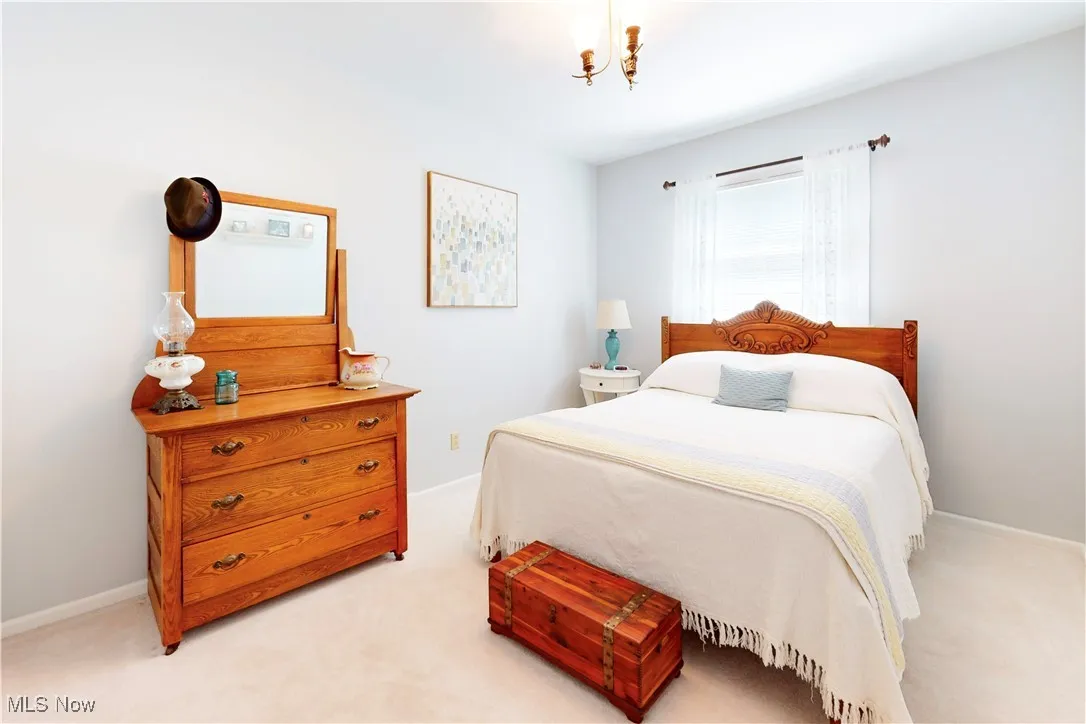 Bedroom featuring light carpet and a chandelier