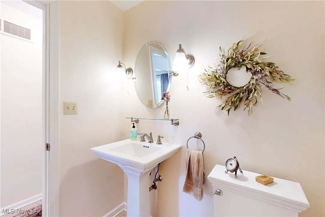 Half bathroom with toilet and baseboards